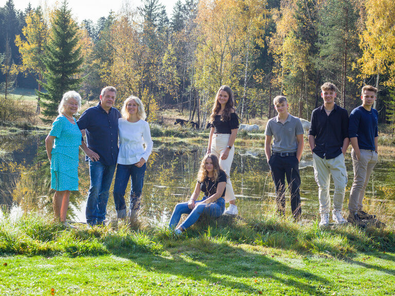 Die Gastgeberfamilie des Fohlenhof in Neuschönau posiert gemeinsam für ein Foto im Grünen.