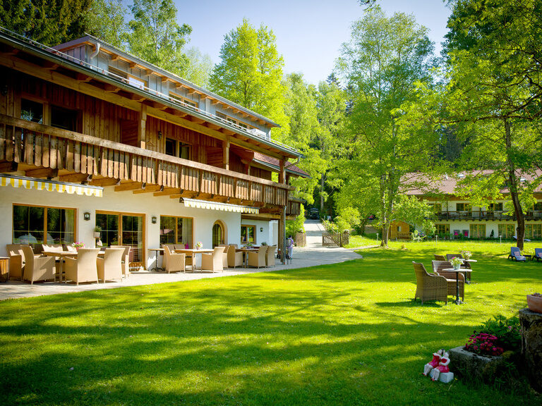 Außenansicht auf den idyllische Fohlenhof mit gemütlichen Sitzmöglichkeiten im grünen Garten.